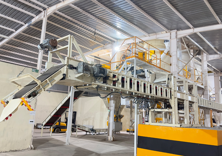 Rotary packing machine with truck loading conveyor.